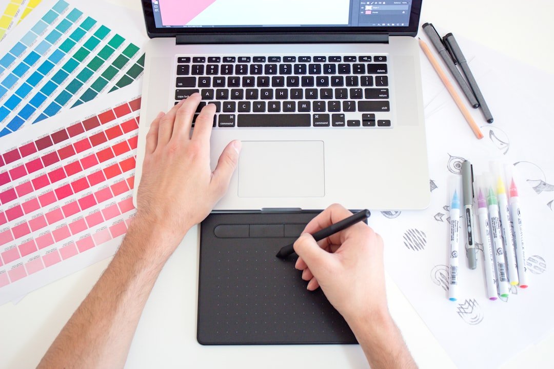 Graphic design workspace with laptop, color tools and creative materials